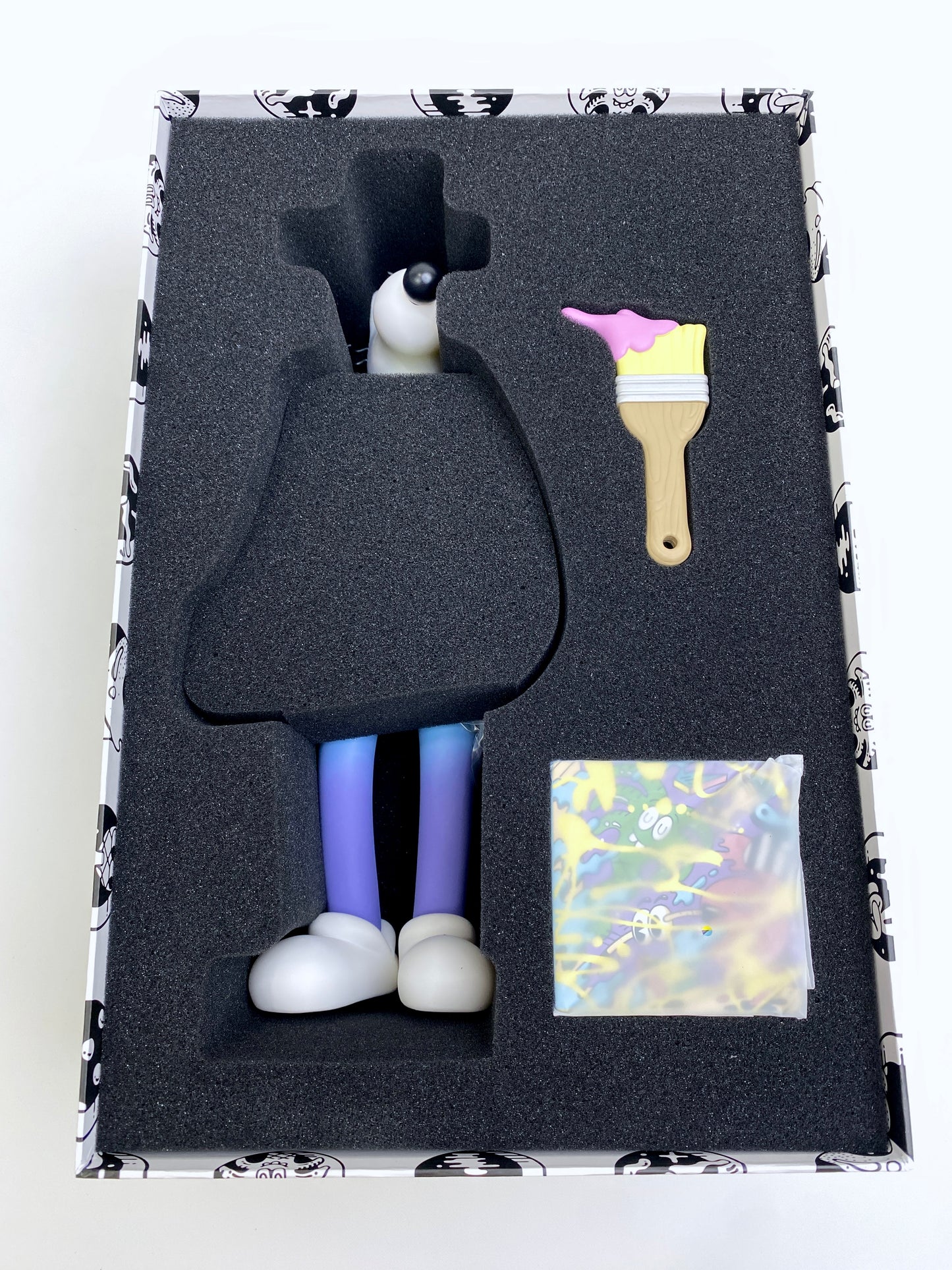 Steven Harrington Subconscious "Gradient" inside box showing vinyl figure, paint brush, and small canvas painting. 